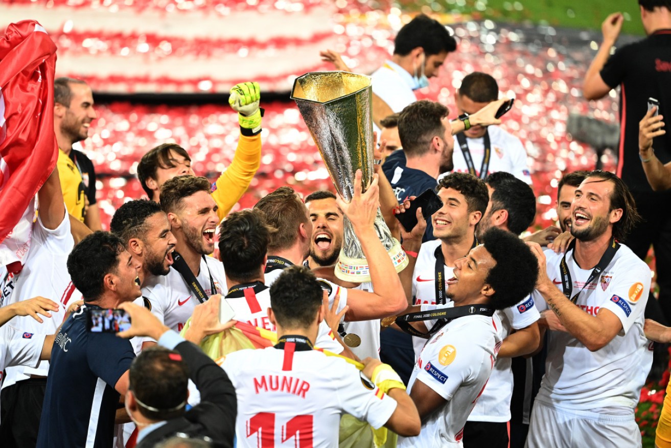 Sevilla players celebrate with the Europa League trophy.