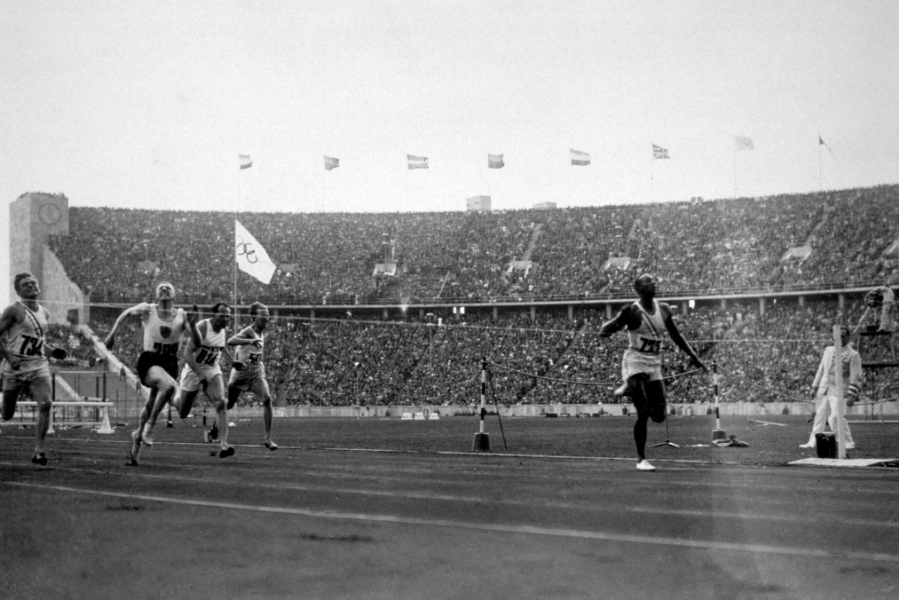 Jesse Owens crossing the finishing line to win the 100 metres at the 1936 Olympics in Berlin.