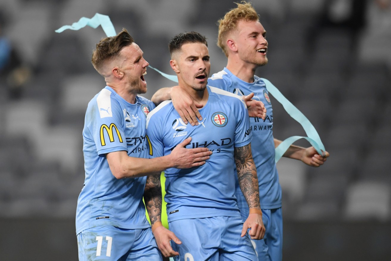 Melbourne City’s Craig Noone and Nathaniel Atkinson flank Jamie MacLaren after his penalty goal on Wednesday night. 