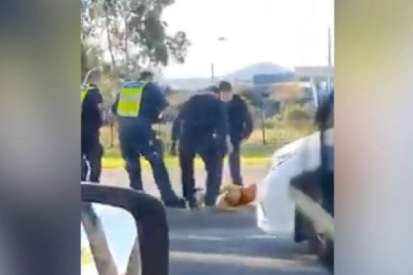 A passing motorist films police arresting a man in Melbourne's north on Sunday.