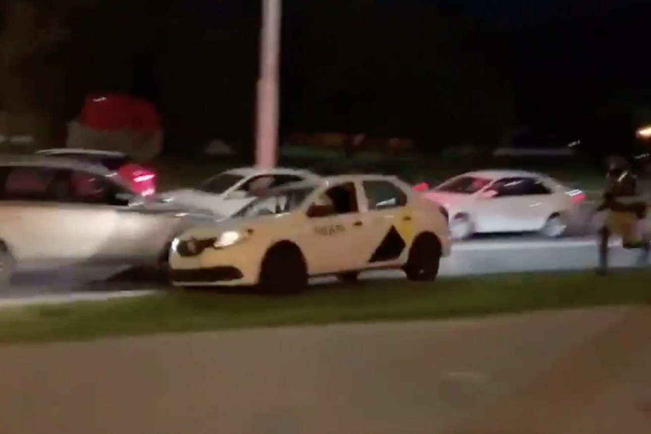 The taxi driver speeds away – mounting the footpath in the process – with the protester aboard.
