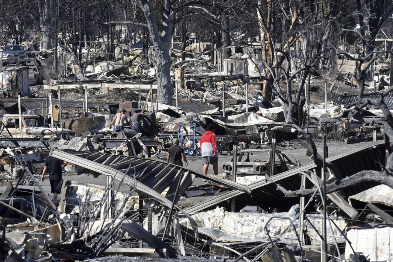 Men walk through the fire-ravaged Coleman Creek Estates mobile home park in Phoenix, Oregon. 