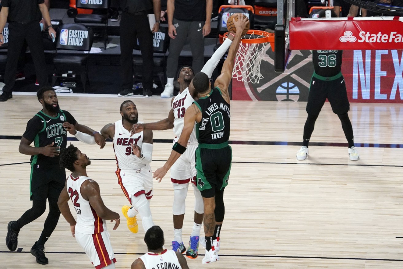 Miami Heat's Bam Adebayo blocks a shot attempt by the Celtics' Jayson Tatum in the closing seconds of overtime.