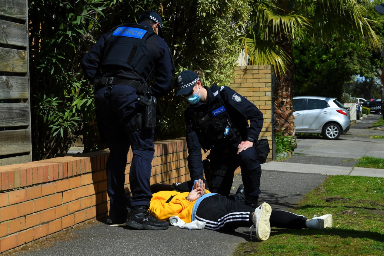 Victoria Police detain an anti-lockdown protester in Elwood.