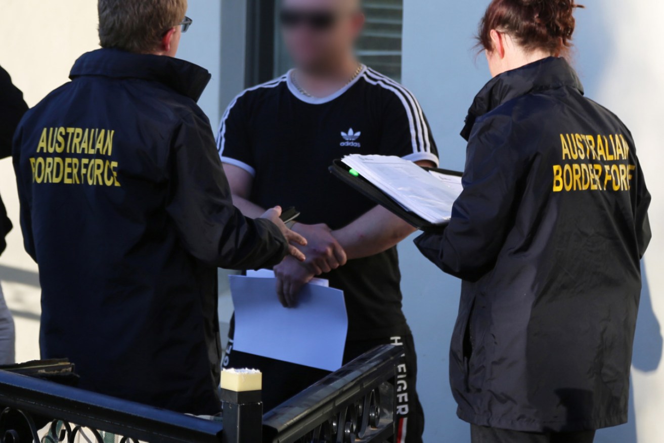 Australian Border Force officers talk with a man at the Bathurst property.