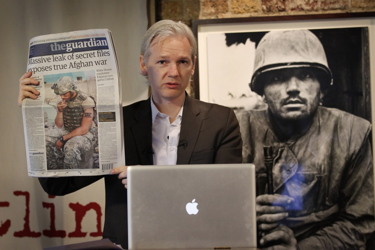 Julian Assange holds up a newspaper reporting on leaks in July 2010 in London, England. Photo: Getty