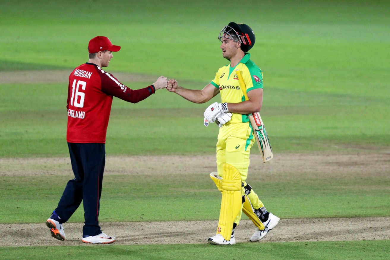 England captain Eoin Morgan, left, bumps fists with Australia's Marcus Stoinis after the match.