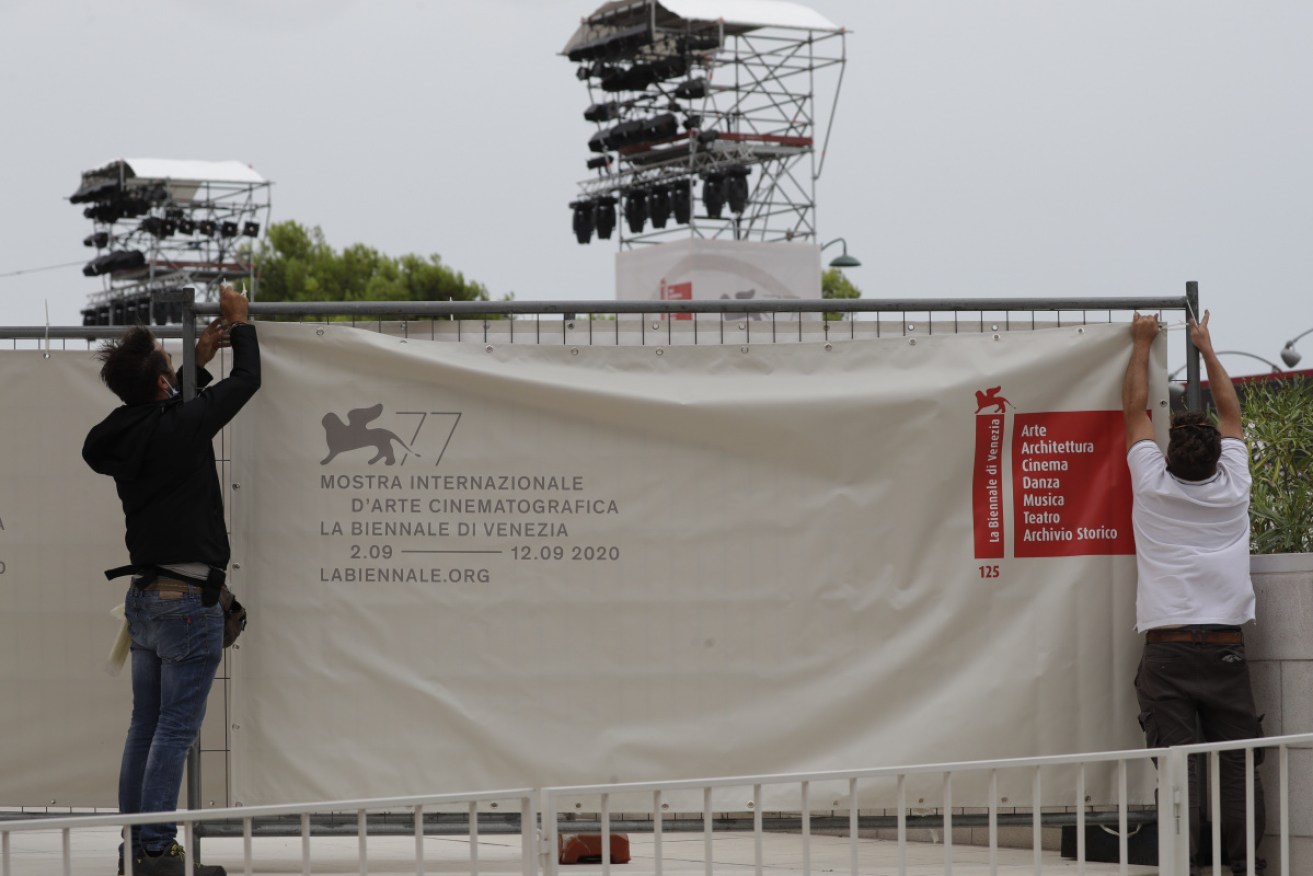 Workers put the finishing touches to the red carpet for the Venice Film Festival.