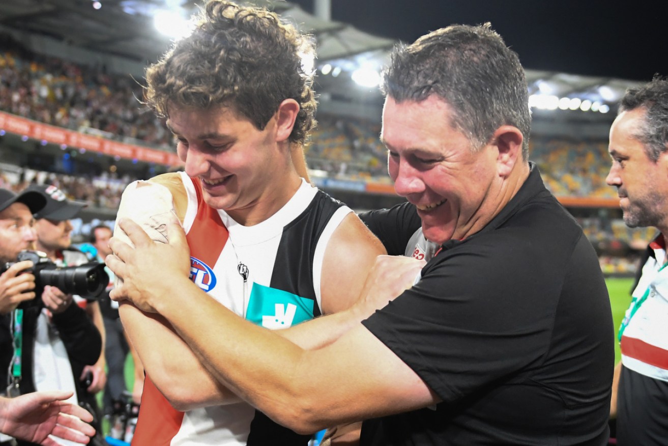 All in together: Nick Coffield of the Saints and coach Brett Ratten celebrate following the win over the Bulldogs. 