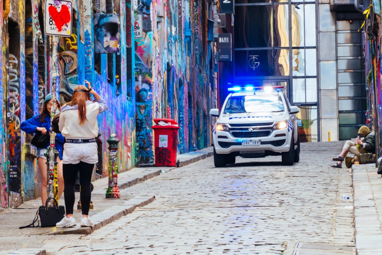 Hosier Lane, in the Melbourne CBD, is all but empty – with police checking the area.