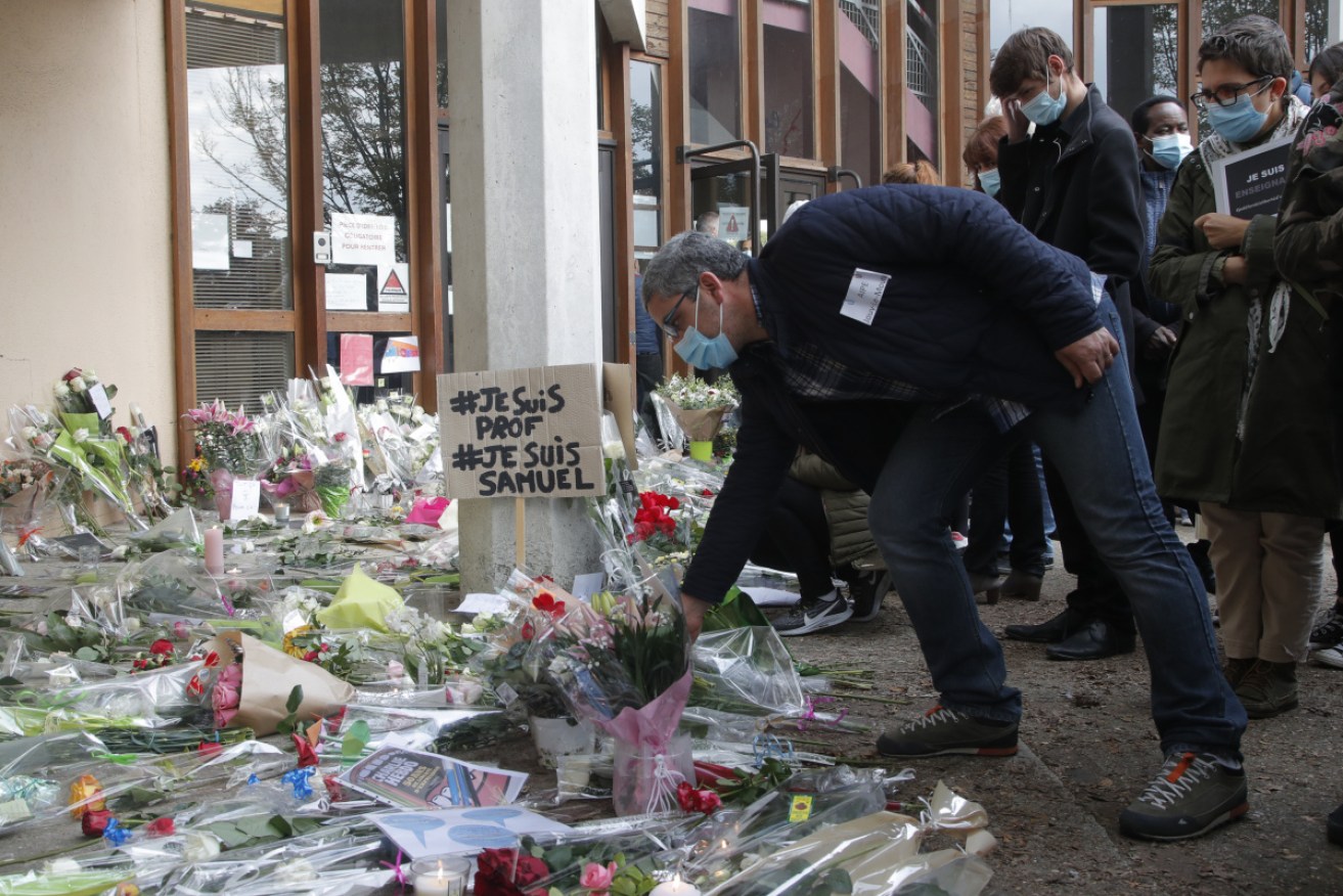 Flowers are laid in a tribute to murdered teacher Samuel Paty.