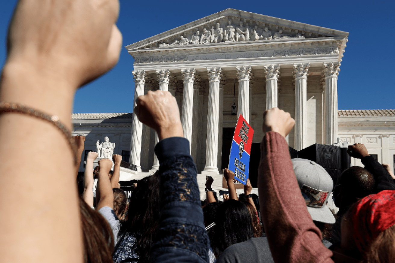 Fists of fury: Protesters show their opposition to Trump and his nominee outside the Supreme Court.