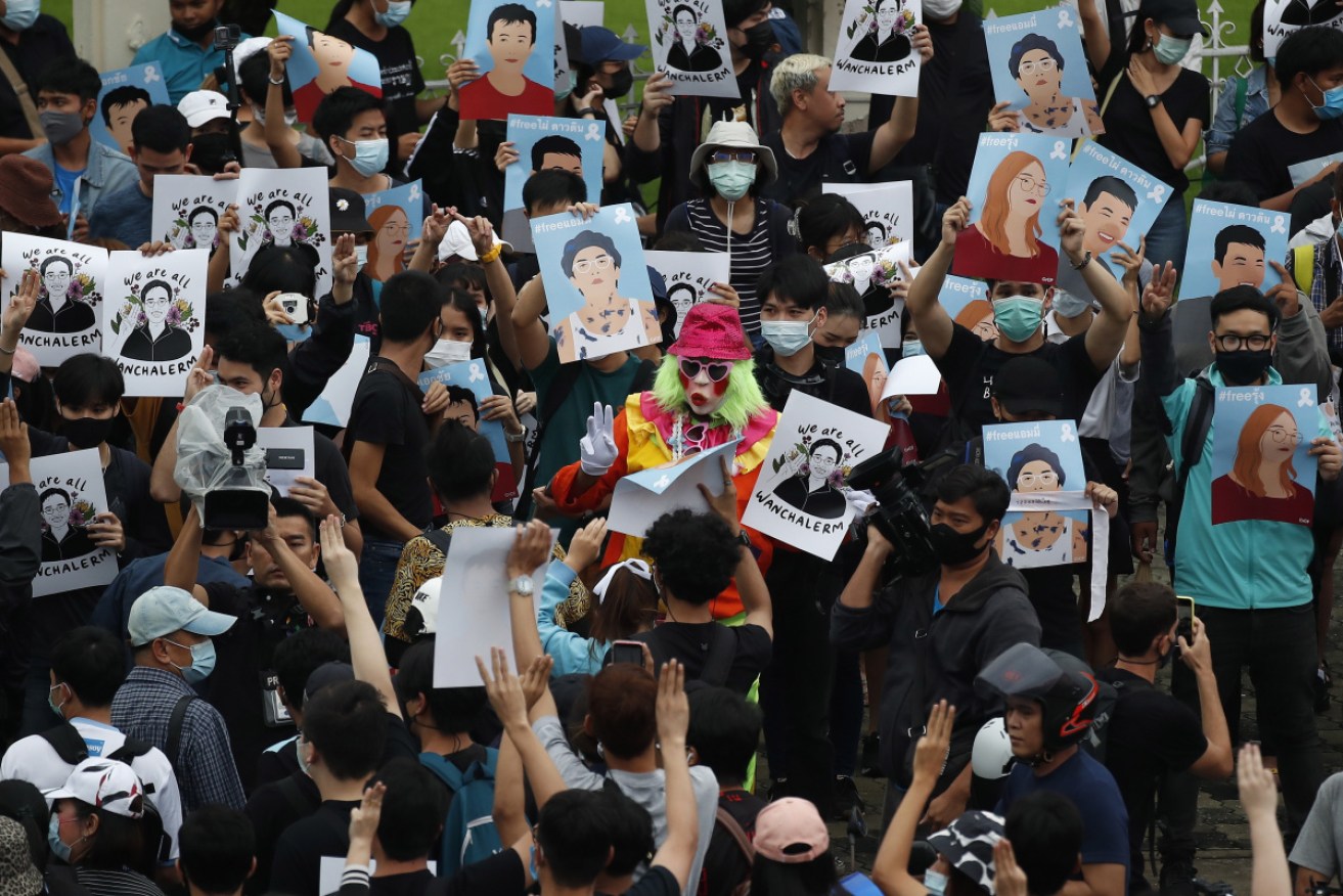 Protestors hold up pictures of pro-democracy activist Wanchalerm Satsaksit at a protest in Bangkok. 