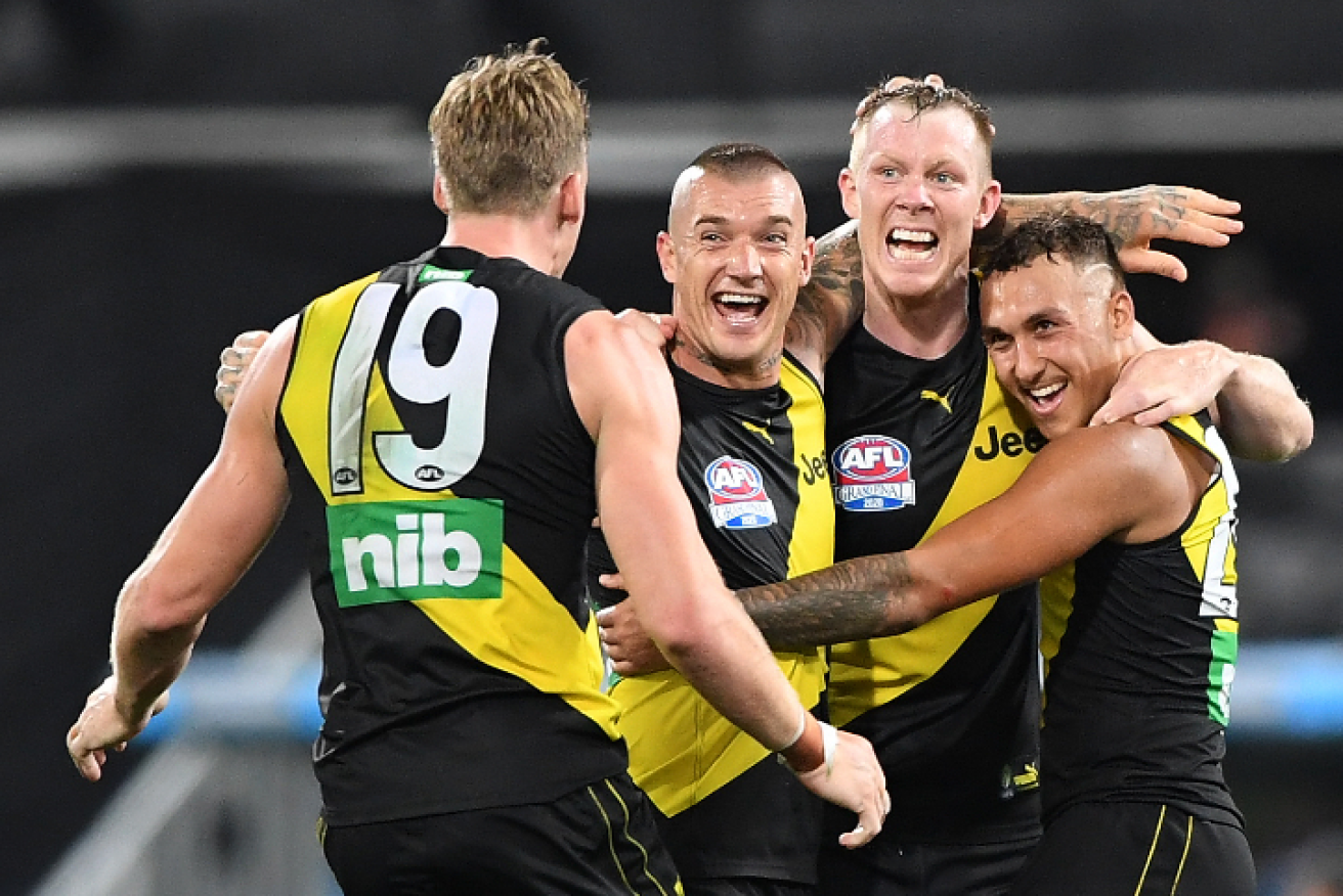 Ecstatic Richmond players fall into each other's arms as the final siren confirms their victory over Geelong.