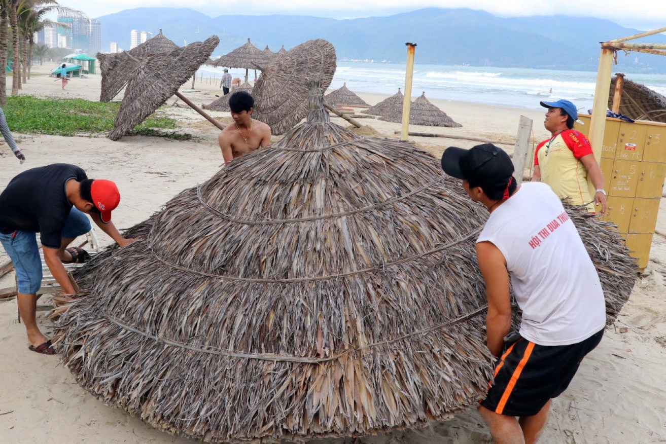 People remove beach cabanas  in Danang, Vietnam before the expected arrival of Typhoon Molave, 