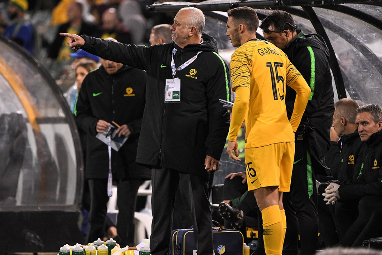 Graham Arnold speaks to Giannou Apostolos in a World Cup qualifier against Nepal in Canberra last October. 