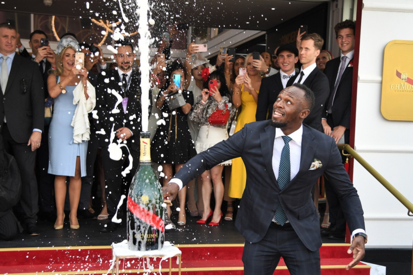 Usain Bolt opens a bottle of champagne in the Birdcage on Melbourne Cup Day.