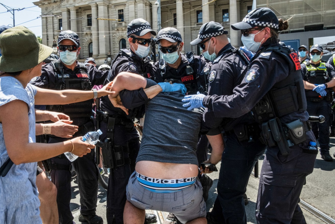 A protester is arrested after clashing with the Police at Parliament House in Melbourne on Tuesday. 