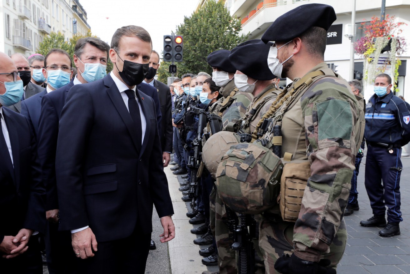 Emmanuel Macron (3rd-L) and Nice Mayor Christian Estrosi (2nd-L) visit the scene of a knife attack.