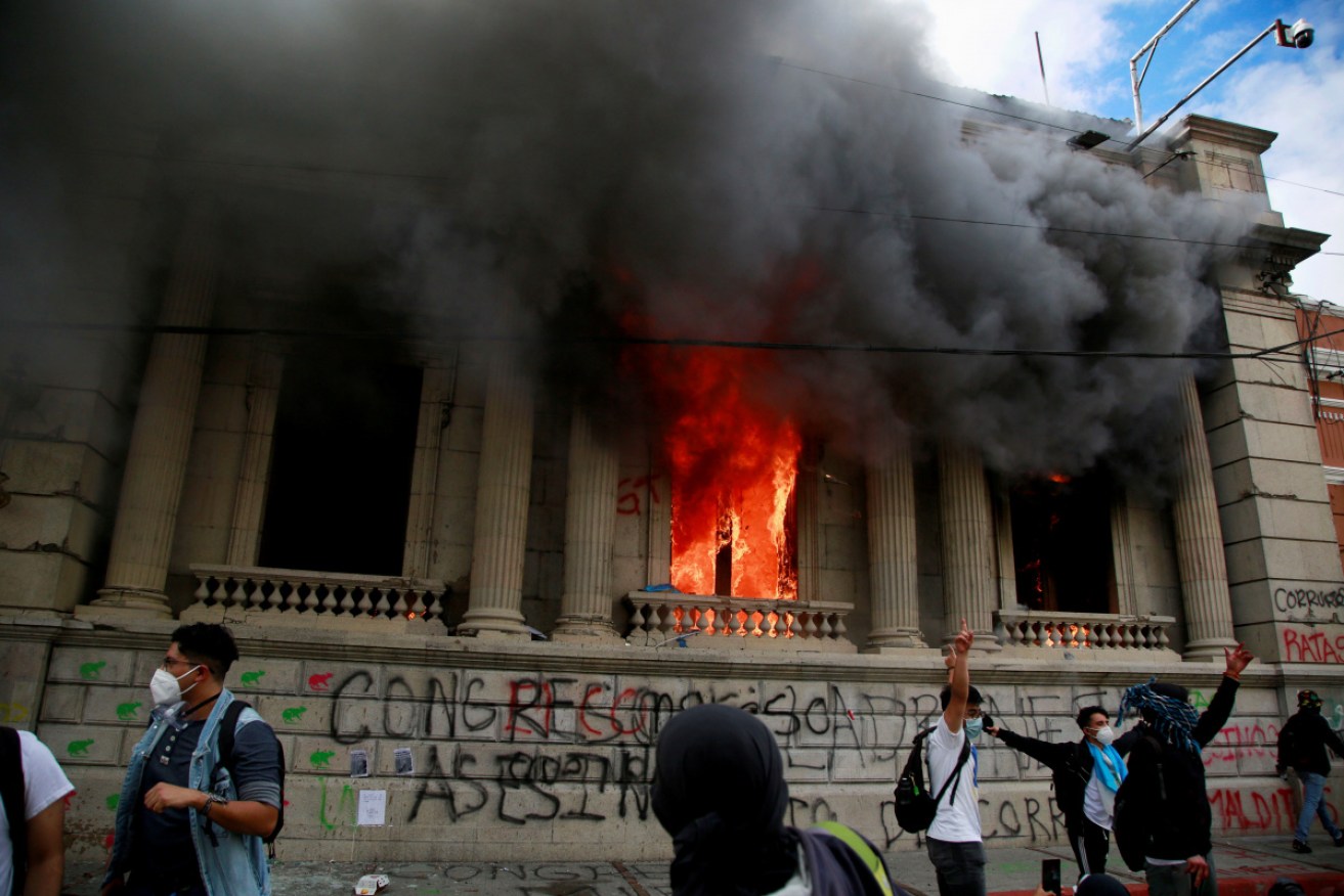 Part of the Guatemalan congress building is set on fire during an anti-government protest in Guatemala City. 