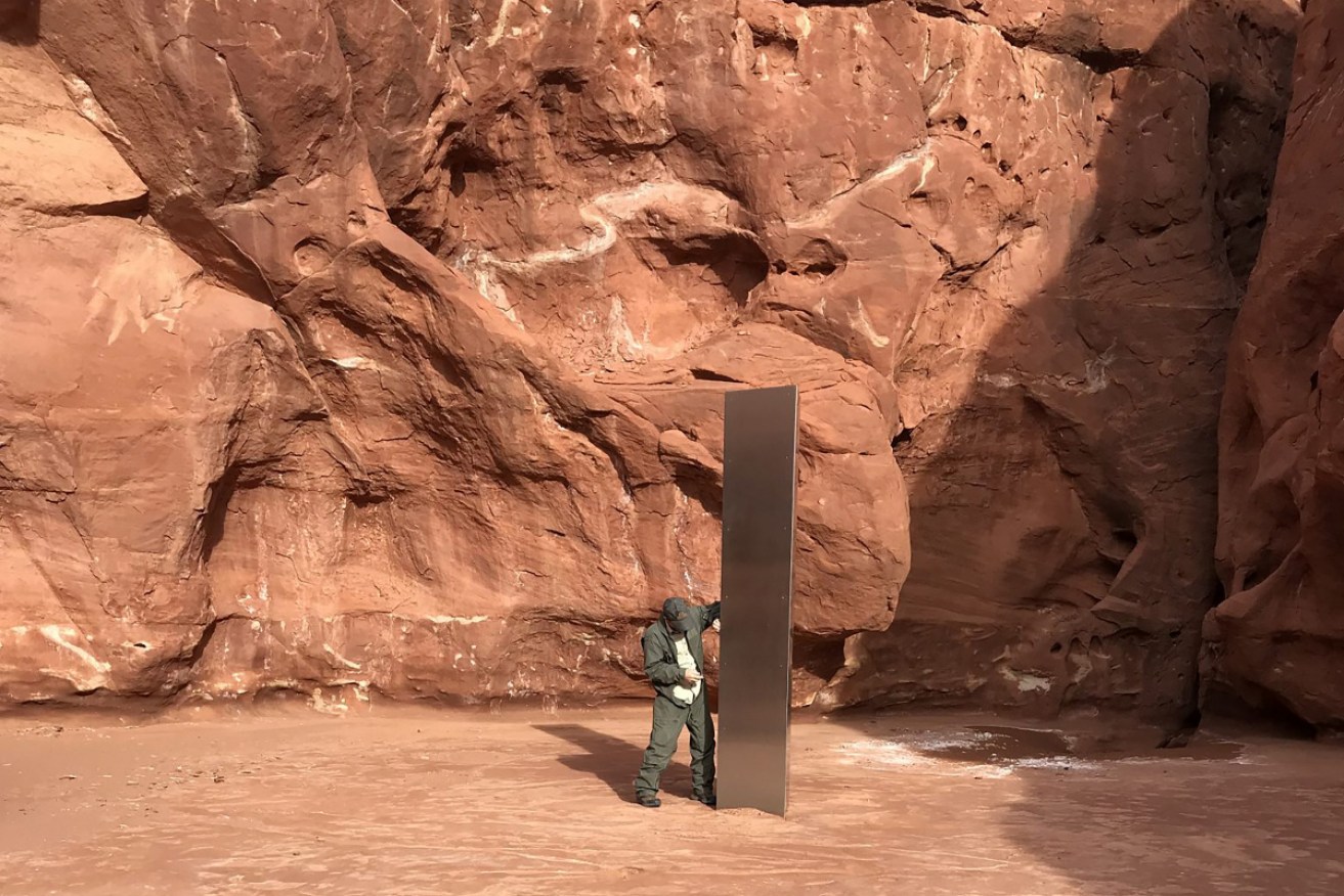 It was there, but now it's gone ... A worker inspects the mysterious monolith.
