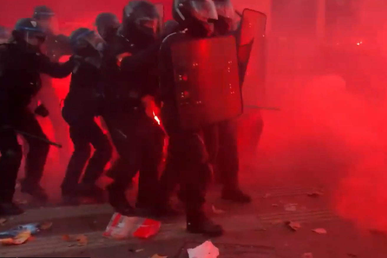 French riot police retreat under a barrage of rocks and bottles. 