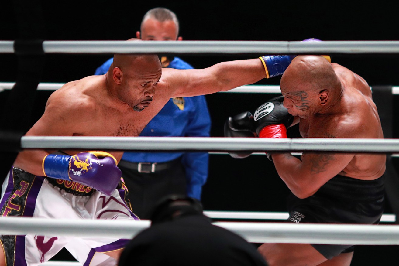 Roy Jones Jr lands a blow on Mike Tyson in their charity bout on Sunday. 