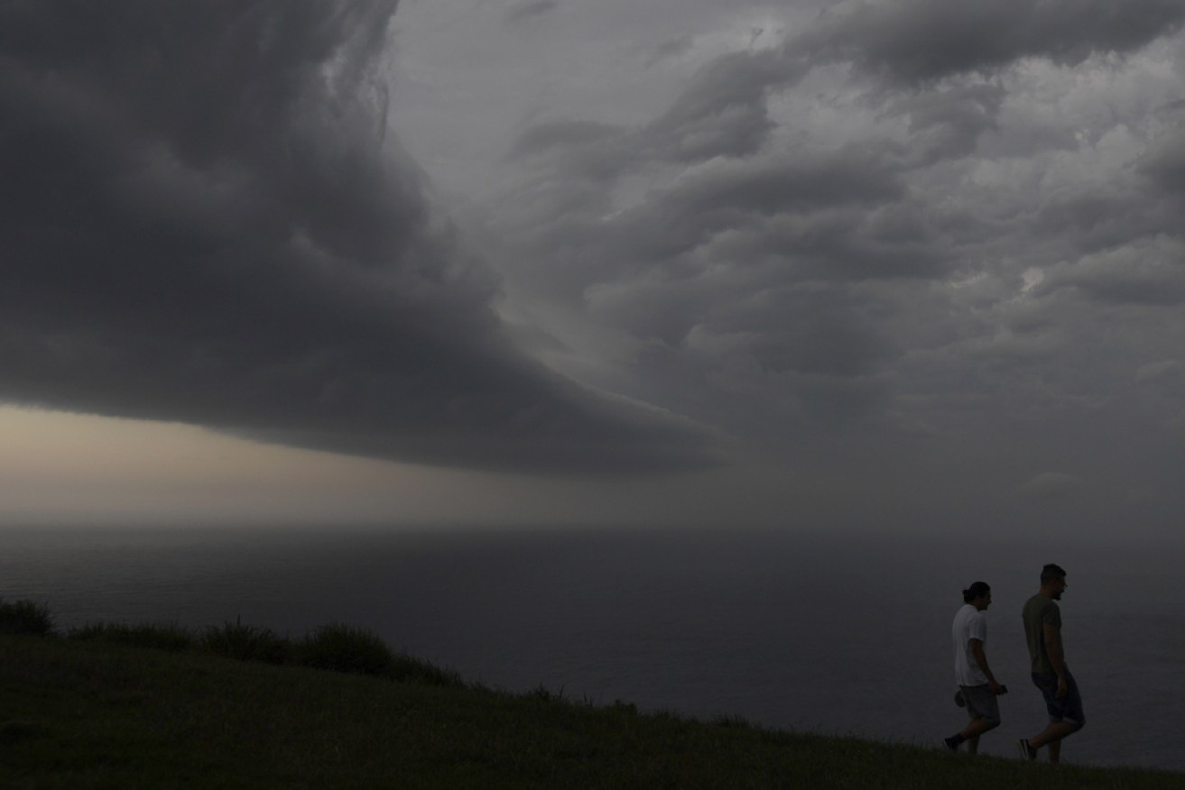 Walkers brave the elements in Wollongong ahead of Tuesday night's storm.