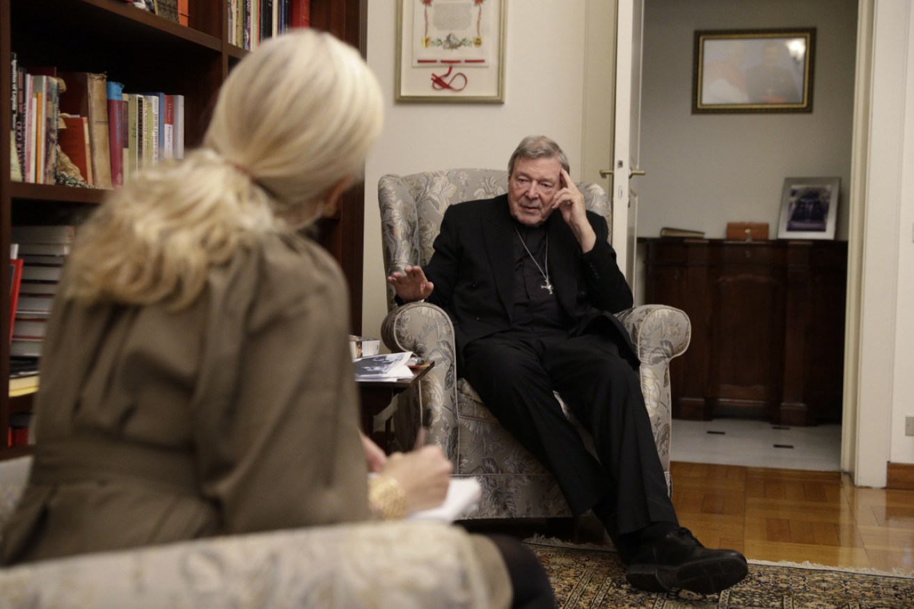 Cardinal George Pell talks to a reporter inside his apartment in Rome.