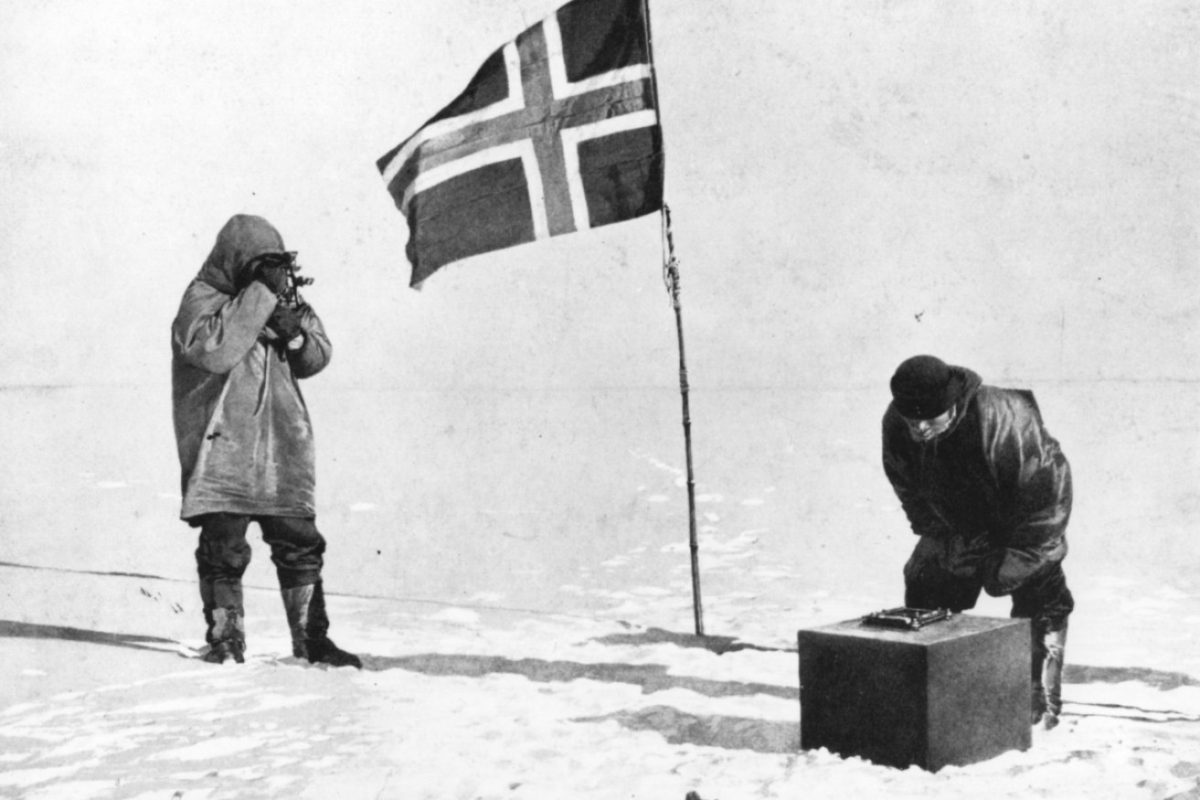 Norwegian explorer Captain Roald Amundsen at the South Pole, beside the Norwegian flag.