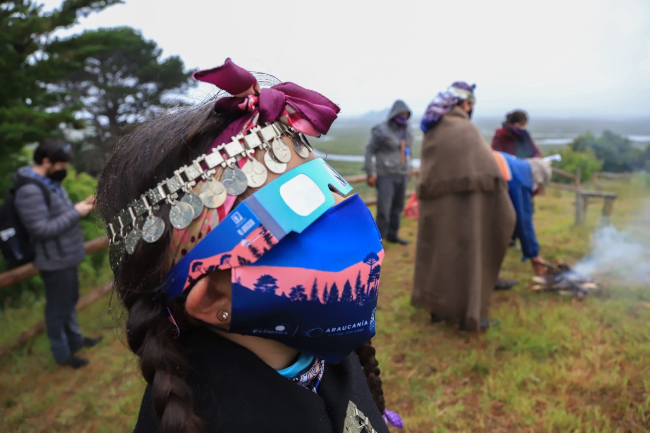 A Mapuche indigenous family watch the solar eclipse in Carahue, in southern Chile.