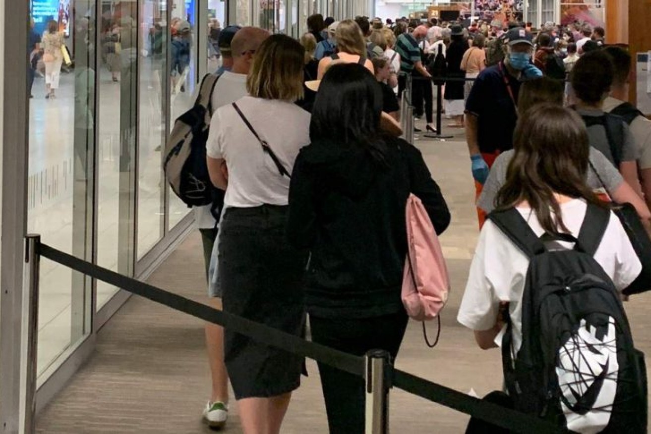 Passengers from Sydney wait to get screened at Adelaide Airport on Sunday night.