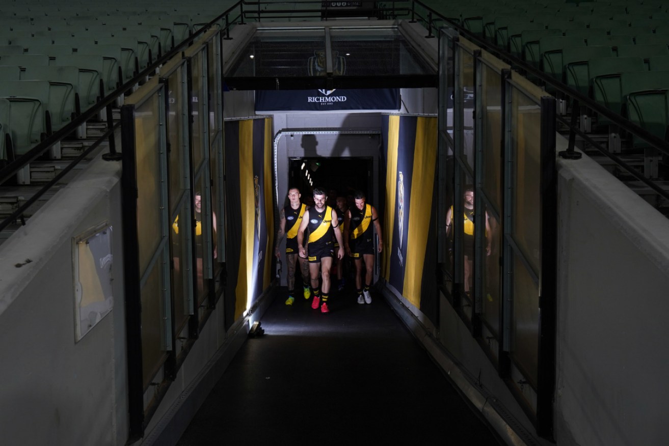 Richmond walk onto the field for their first game of 2020 against Carlton at an empty MCG. 