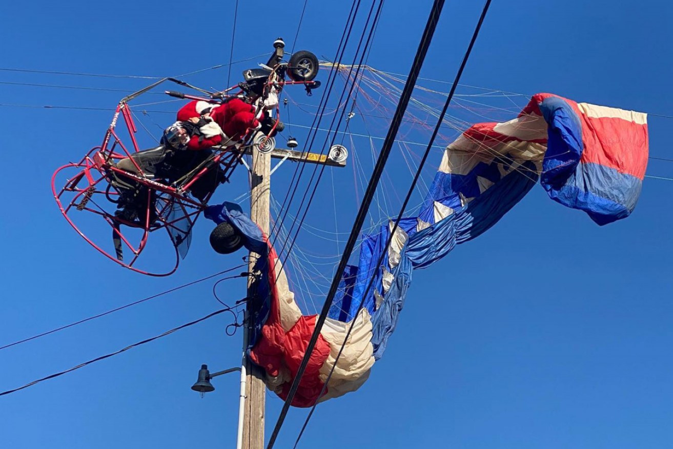 Stuck on some power lines, "Santa" can only wait to be rescued.
