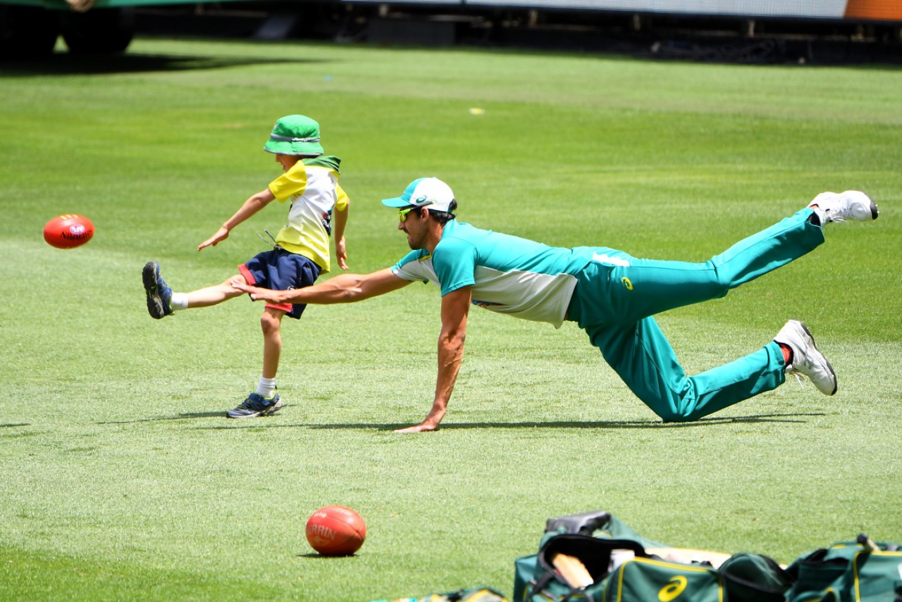 Footy's back at the MCG: Australian cricket Mitchell Starc and youngster at the MCG this week.