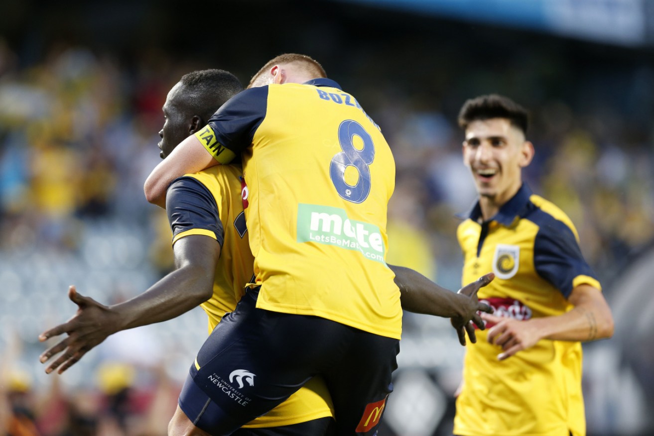 Central Coast teammates mob Alou Kuol after his first-half goal against Newcastle Jets in Gosford on  Thursday.
