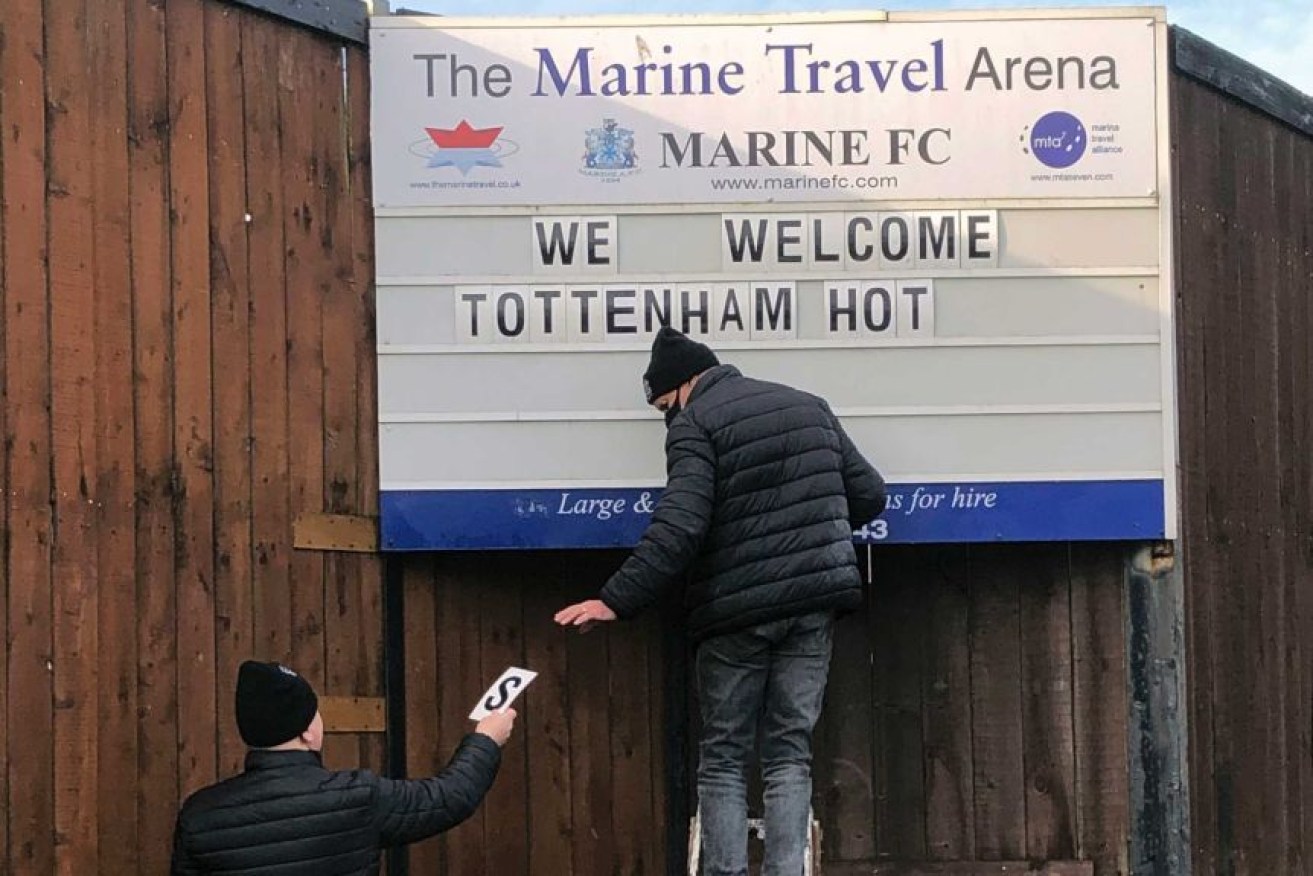 Marine FC volunteers set up the welcome sign for Tottenham Hotspur in the FA Cup.