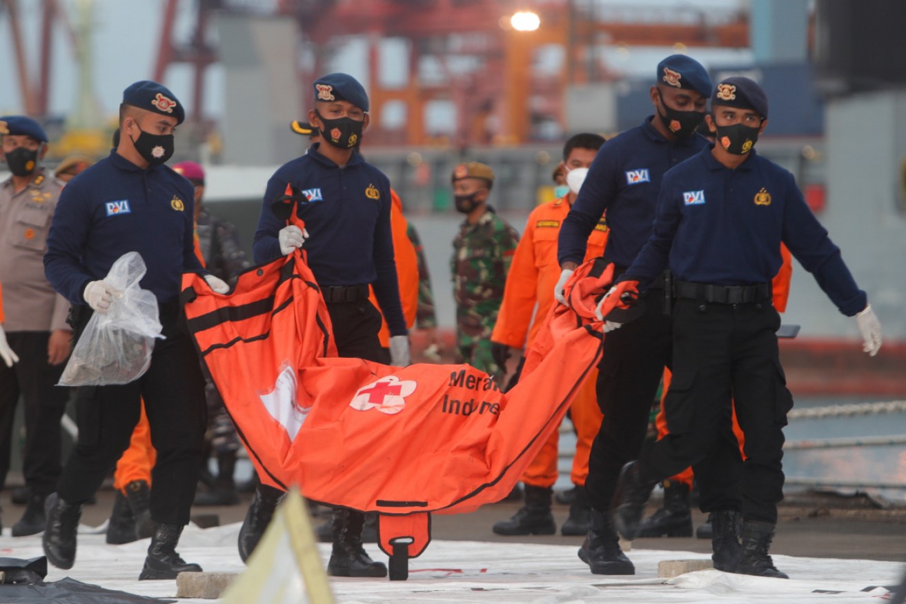Members of the disaster victim investigation team carry a body bag at Tanjung Priok port in Jakarta on Mnday.