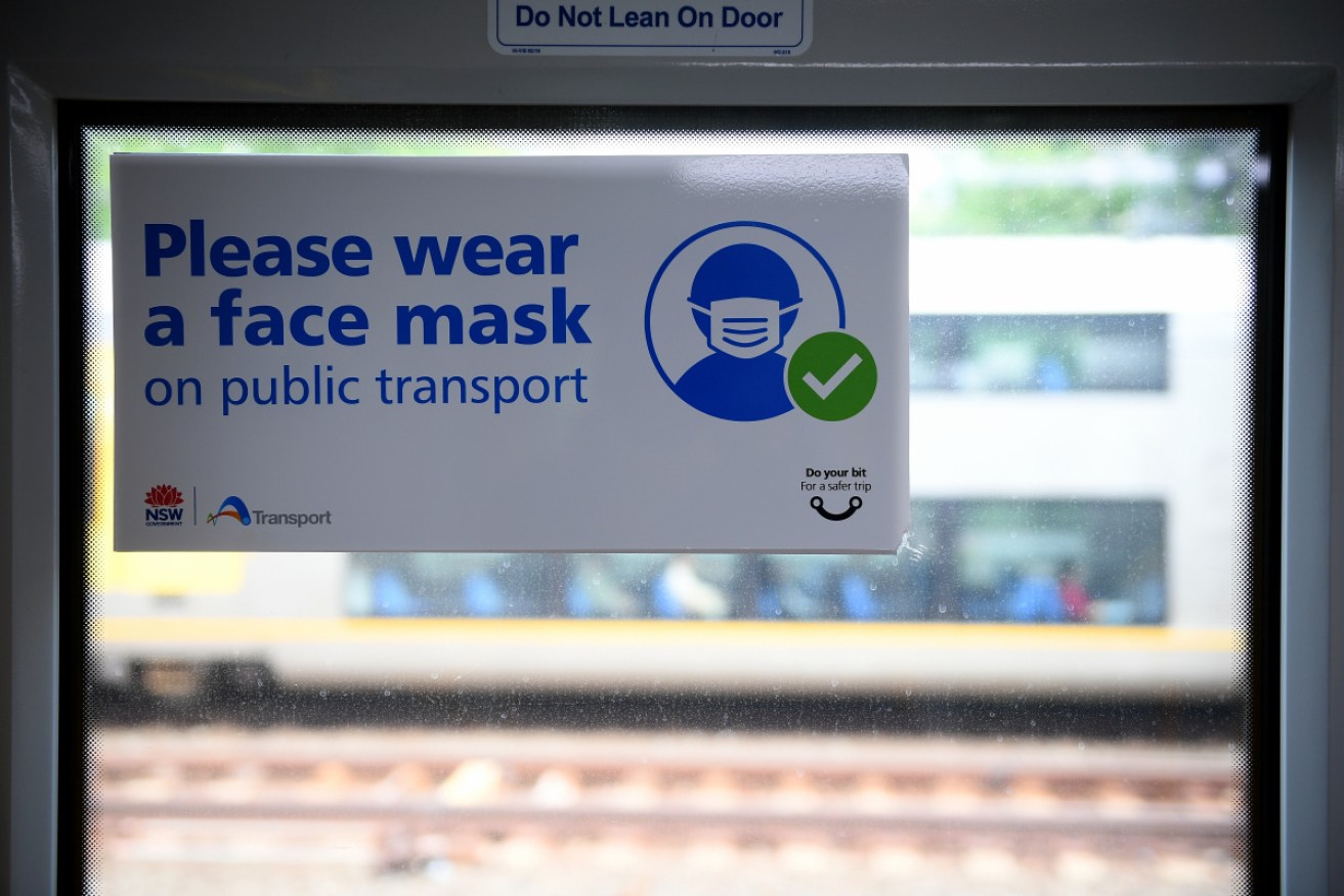 A sign urging commuters to wear a face mask alerts train commuters in Sydney.