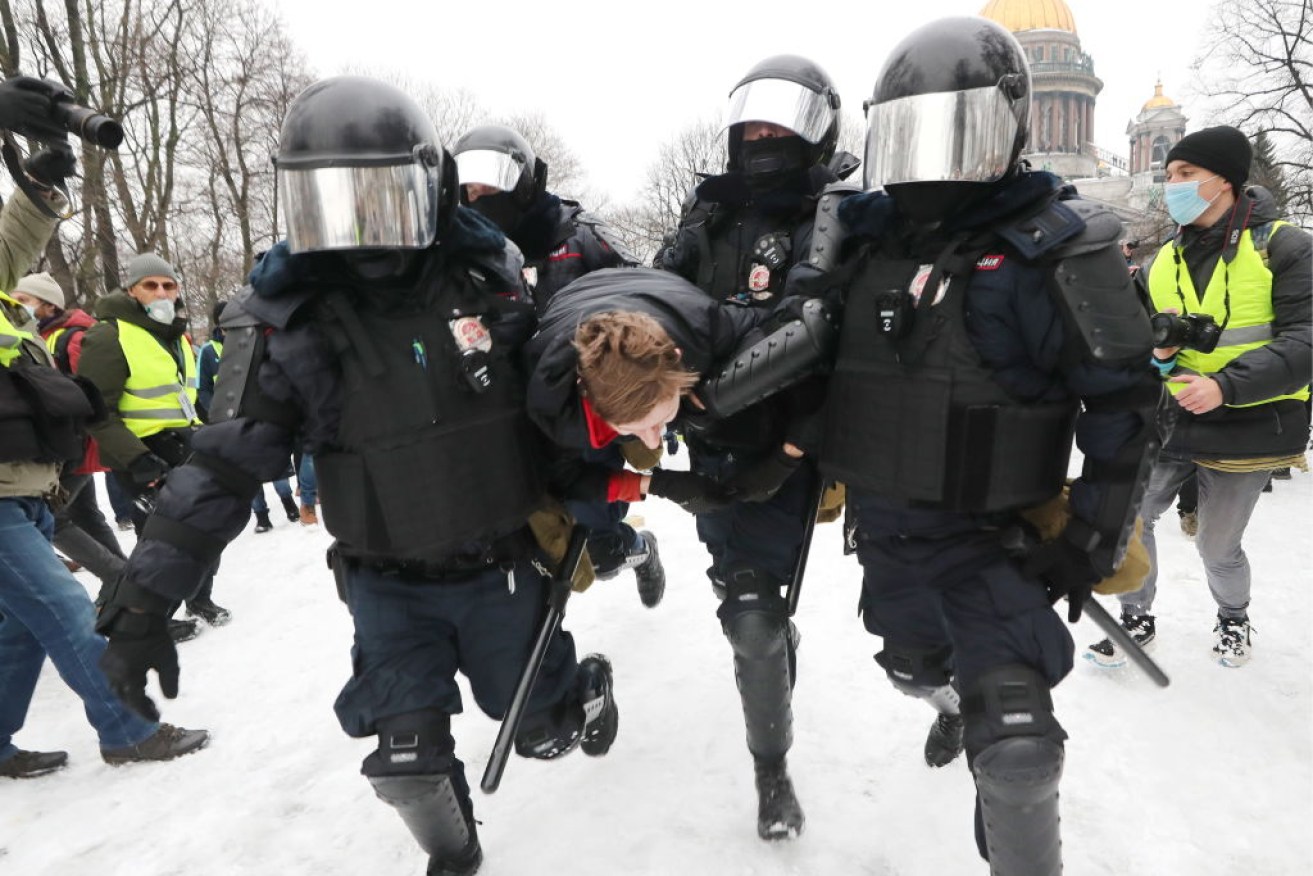Riot police officers detain a rally participant in St Petersberg.