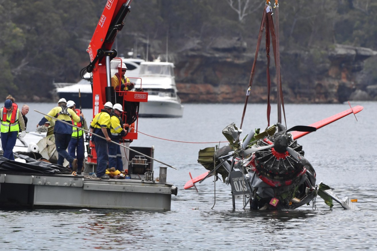 NSW police and salvage personnel  recover the wreckage of the seaplane in 2018.