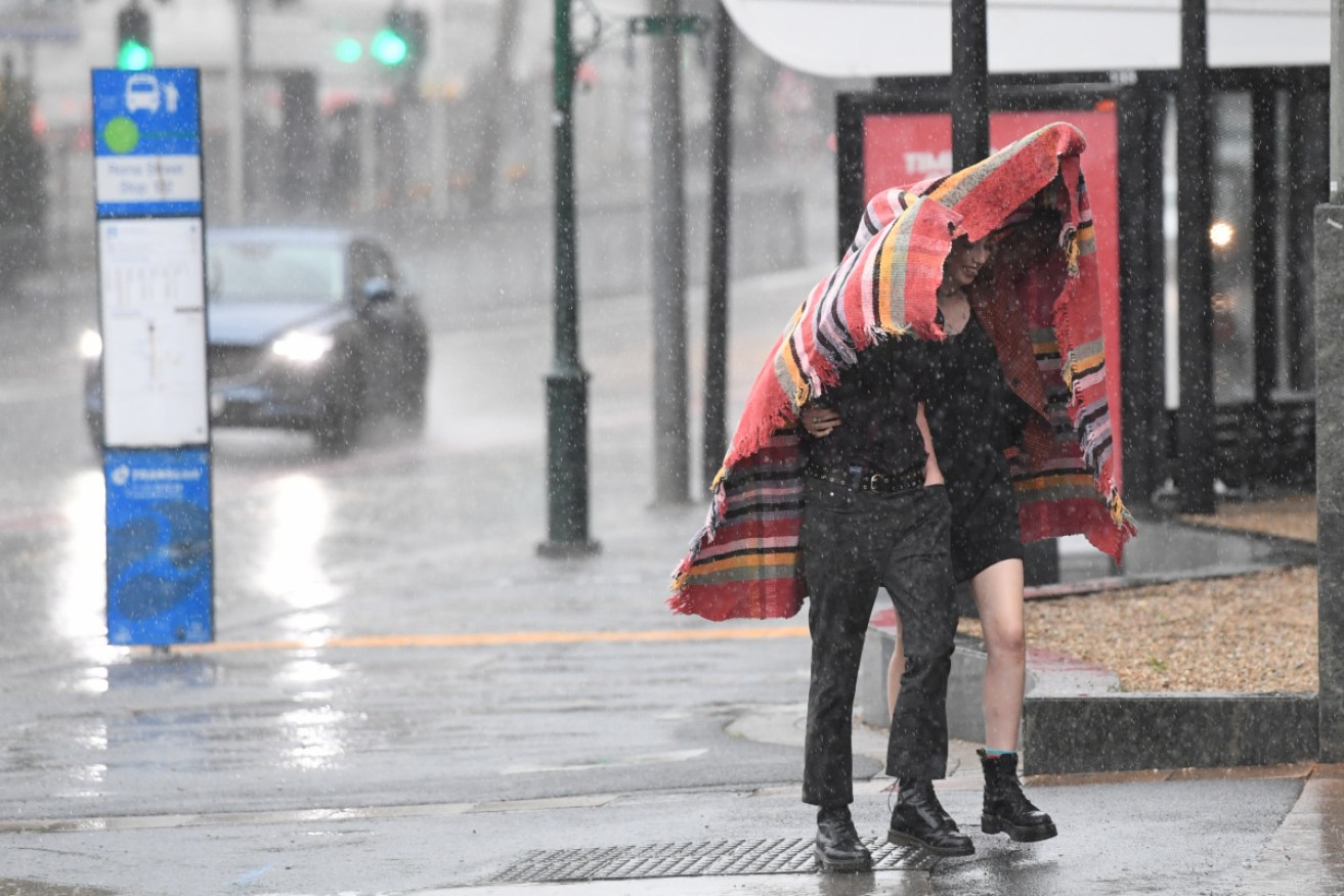 People shelter from the rain as the storm hits Brisbane on Tuesday morning.