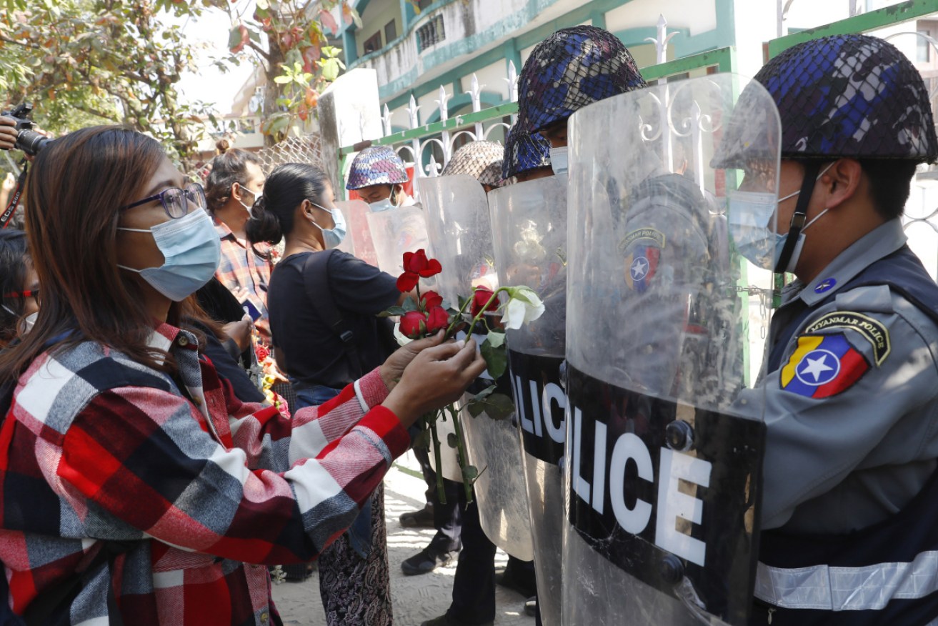 Supporters give roses to police while four arrested activists make a court appearance in Mandalay, Myanmar.