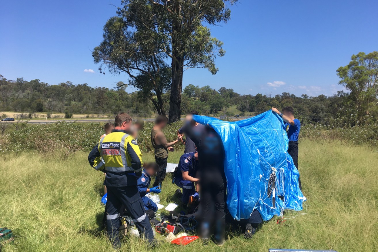 A skydiver is treated  by paramedics. 