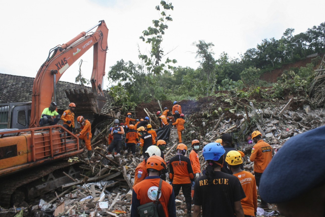 Rescuers search for victims in the ruins of houses damaged by a landslide at Nganjuk, East Java, on Monday.