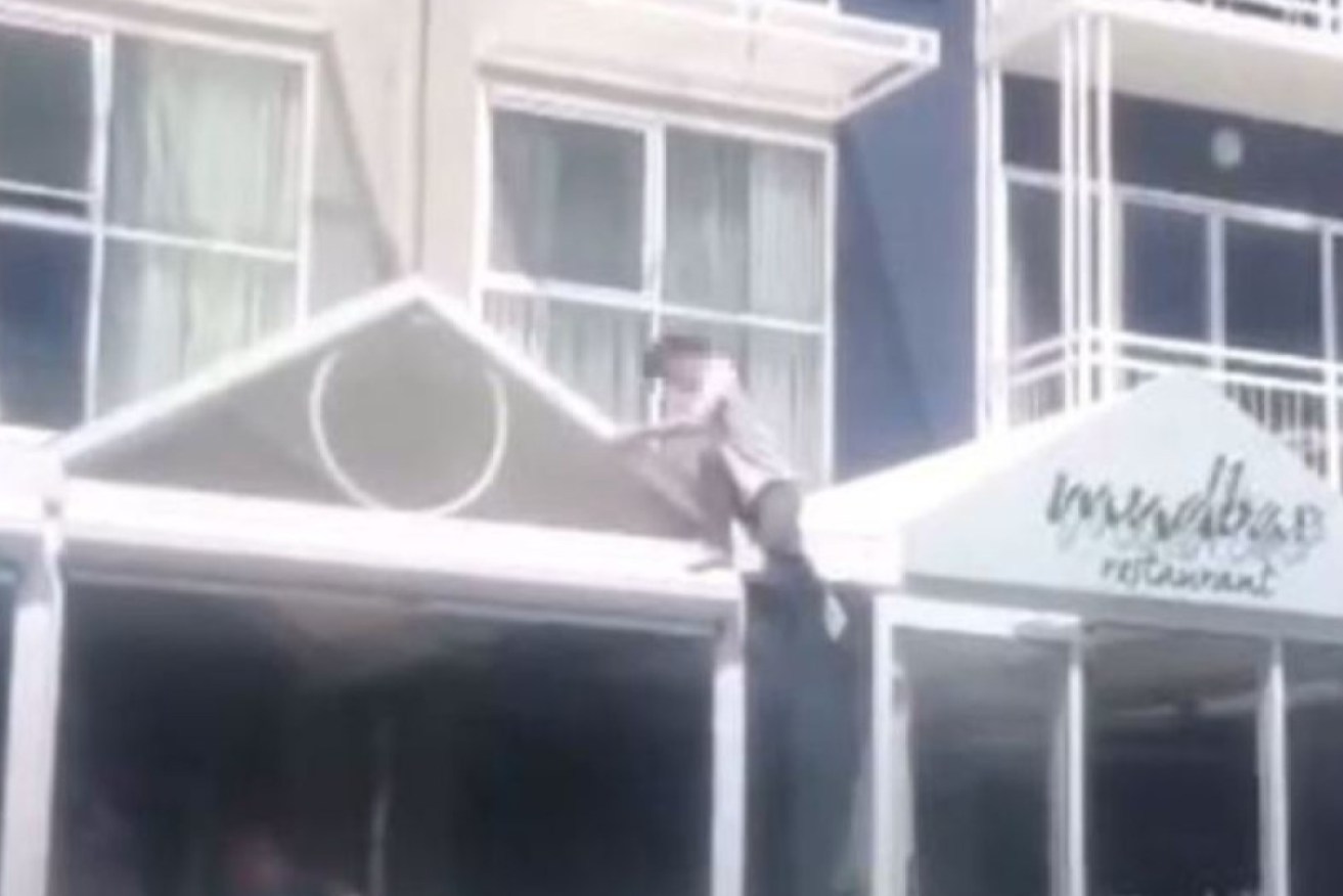 Footage has emerged on social media showing a person climbing down from a hotel awning.