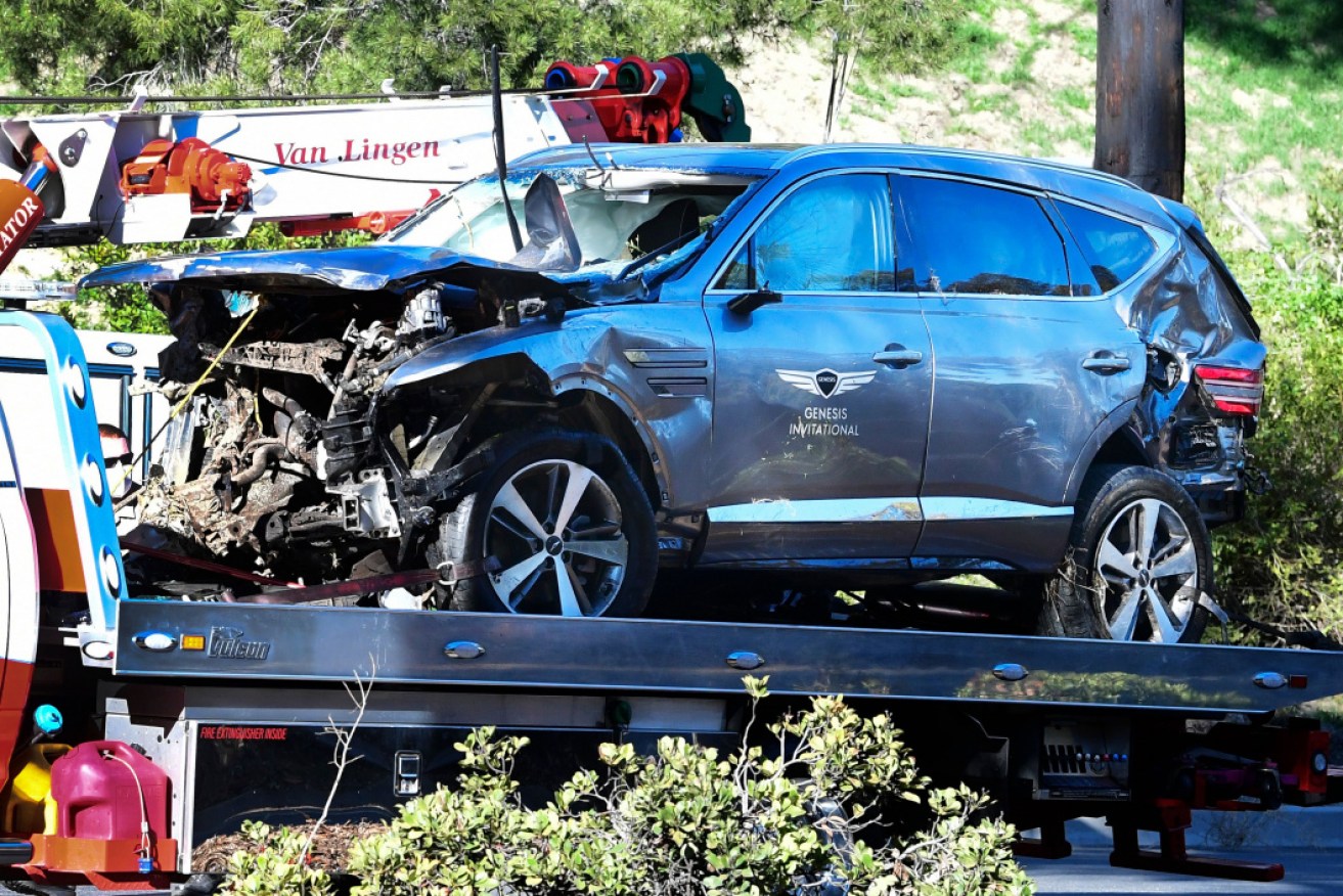 Woods' damaged car is loaded onto a tow truck after Tuesday morning's high-speed crash.