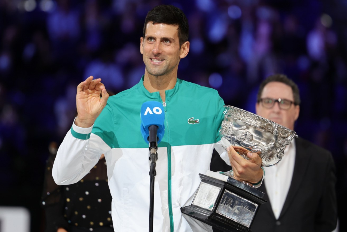 Top seed Novak Djokovic poses with his latest Australian Open  trophy.
