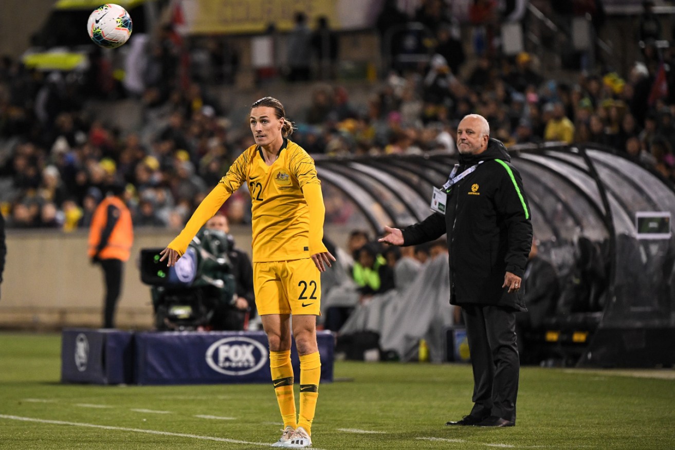Jackson Irvine throws in the ball as Socceroos coach Graham Arnold looks on against Nepal in Canberra in October 2019.
