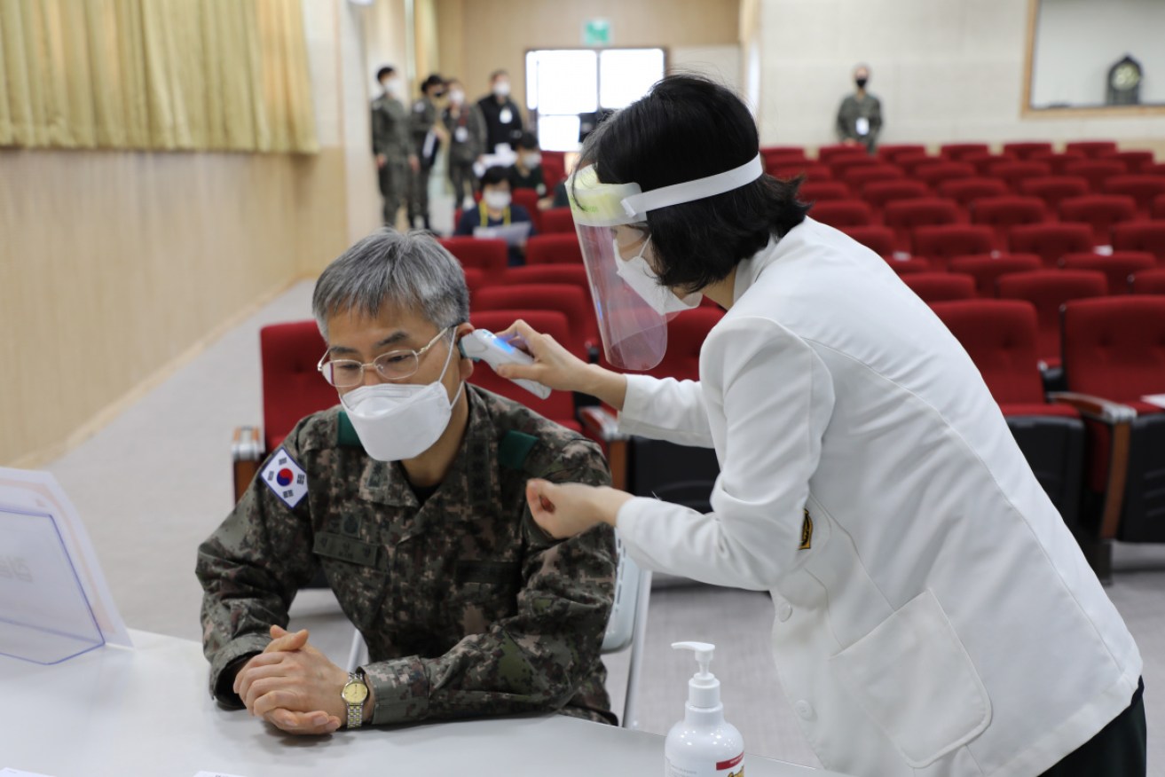 Colonel Kim In-young, head of the Korean Army Yangju Hospital, undergoes a temperature check before his COVID-19 shot in Yangju on Wednesday.